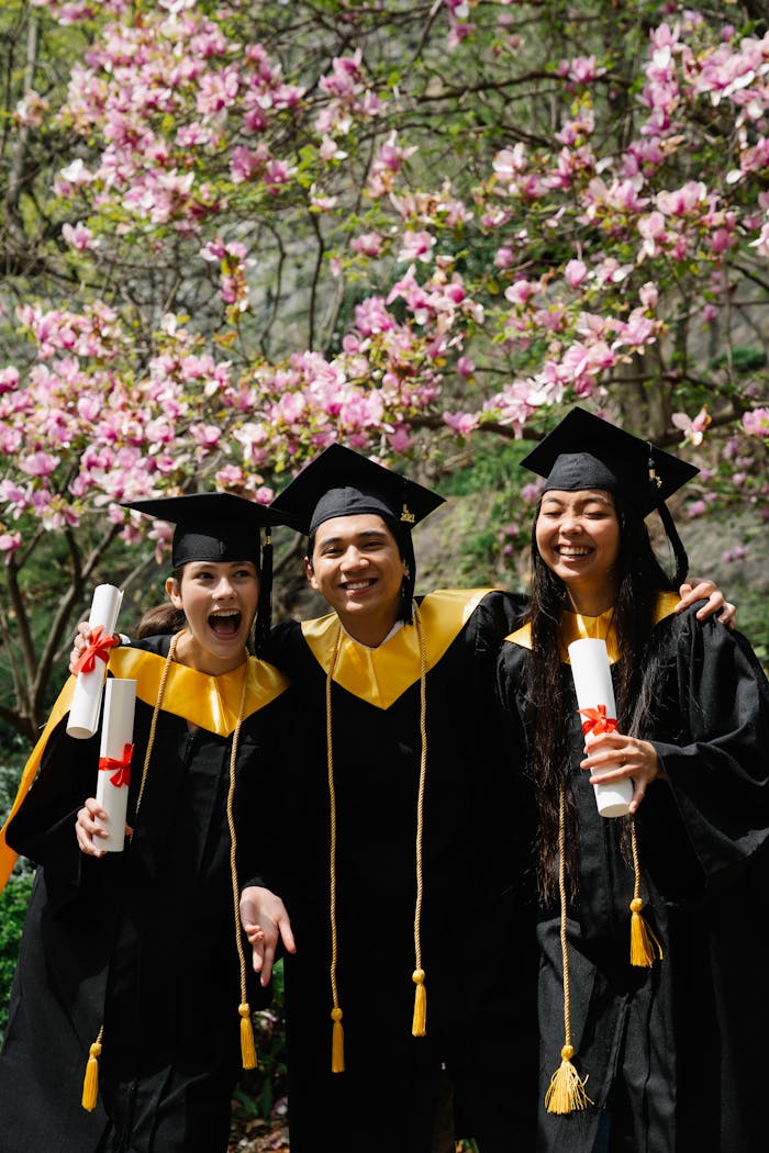 Joyful graduates in caps and gowns celebrating together with diplomas.